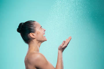 Woman enjoying water in the shower under a jet