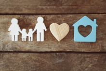 Family Figure With A House On Wooden  Background