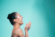 Woman Enjoying Water In The Shower Under A Jet