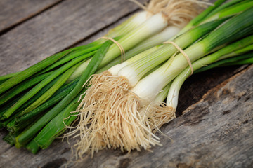 Wall Mural - Green scallions heaps, on wooden surface