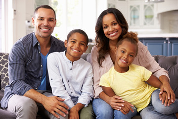 Portrait of parents and young children relaxing at home