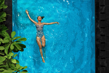 Woman In Pool Water. Beautiful Happy Girl With Sexy Fit Body Relaxing, Floating In Swimming Pool At Spa Hotel. Summer Holidays Vacation. Healthy Lifestyle. Wellness, Beauty, Health Concept. Recreation