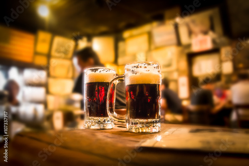 Cuadros en Lienzo Defocused bar borroso con 2 tazas de cerveza en el foco