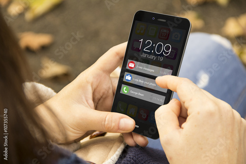 Fotomural woman with notifications screen on phone in the park