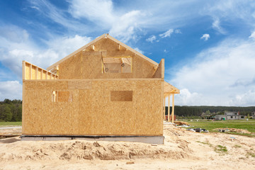 Wall Mural - New residential construction home framing against a blue sky