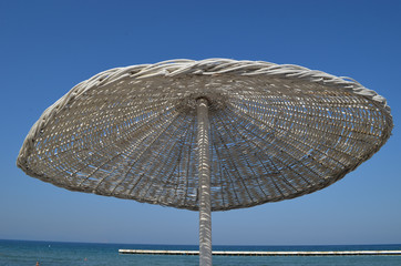 White reed parasol on the beach at the Turkish Riviera close to Kusadasi