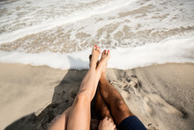 Couple Sitting On The Shore. Only Legs Visiable 