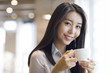 © Blue Jean Images - Young woman drinking coffee in caf_