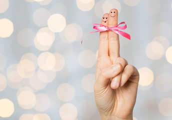 Canvas Print - close up of two fingers tied by pink bow knot