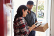 © Monkey Business - Woman Signing For Package From Courier At Home