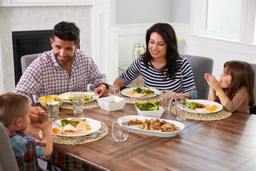 Hispanic Family Enjoying Meal At Table