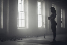 Black Woman Standing In Dark Gym