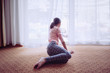 © Donald Iain Smith/Blend Images - Mixed race girl sitting on floor looking out window