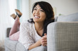 © JGI/Jamie Grill/Blend Images - Pacific Islander woman laying on sofa