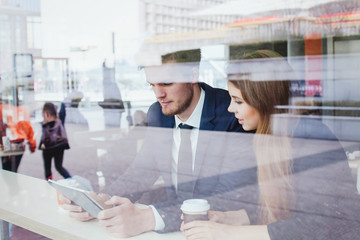 business people in cafe looking at the screen of tablet