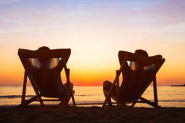 Wall Mural - enjoy life concept, couple relaxing in beach hotel at sunset, happy people on honeymoon, paradise tr
