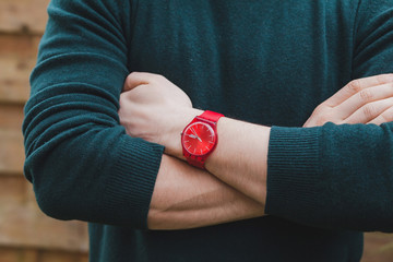 mens fashion, close up of hands of male wearing red watch and green pullover, style concept