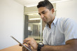© Kevin Dodge/Blend Images - Asian businessman using digital tablet in office