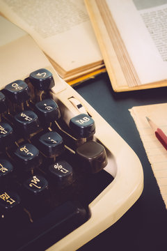 Old typewriter and old book on black table background vintage color