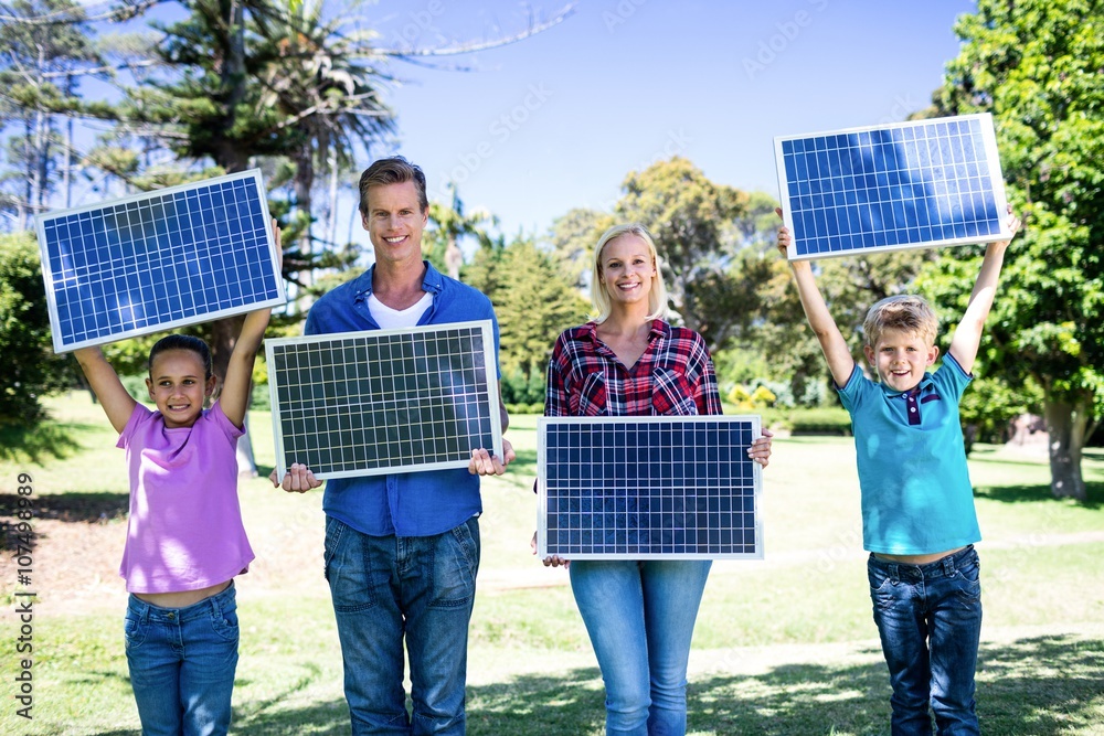 Family holding a solar panel - obrazy, fototapety, plakaty 