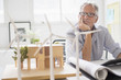 © JGI/Tom Grill/Blend Images - Older Caucasian architect examining scale model in office