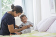 © JGI/Tom Grill/Blend Images - Mixed race mother tickling baby son on bed