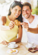 © JGI/Daniel Grill/Blend Images - Hispanic couple sharing cookie at cafe