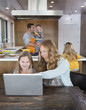 © Sam Diephuis/Blend Images - Caucasian family relaxing in kitchen