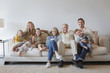 © Sam Diephuis/Blend Images - Caucasian multi-generation family sitting on sofa in living room