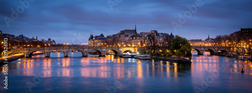 Plakat Świt w pochmurny poranek w Paryżu, z Ile de la Cite, Pont Neuf i Sekwany odzwierciedlające światła miasta. Francja