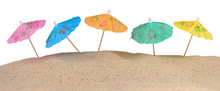 Cocktail Umbrellas In Sand On A White