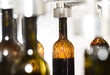 Wine bottle filling along conveyor belt in bottling factory 