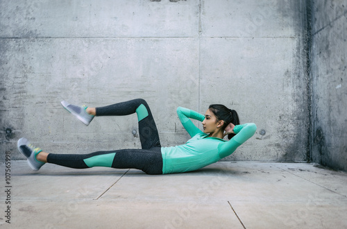 Fotografie, Obraz Young woman performing core crunch exercise