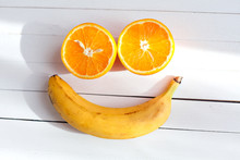 Smiling Face Made From Fruit On A Wooden Background. Fruit Smile. Two Halves Of Oranges, And One Banana. Vitamins For A Good Mood