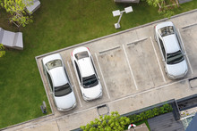Top View Of Cars Park In Outdoor Parking Space Area With Small Garden In Modern Building