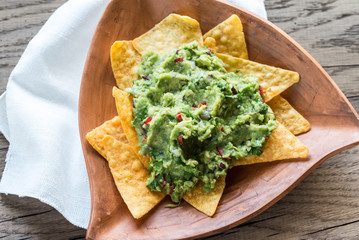 Poster - Guacamole with tortilla chips on the wooden background