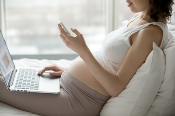 Pregnant woman looking at smartphone screen