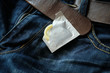 Condom in the blue jeans. Focus on the condom.