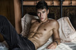 © theartofphoto - Shirtless sexy male model lying alone on his bed