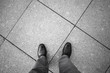 Feet of an urbanite man in black new shining shoes