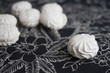 Top view of Latvian marshmallovs - zefiri on white background with dark floral tablecloth