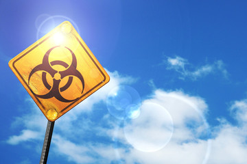 Wall Mural - Yellow road sign with a blue sky and white clouds: Bio hazard si