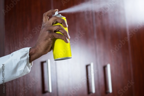 Fotomural Hand spraying pesticide from a spray can