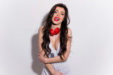 Young, happy and sexy girl with red lips with headphones in a t-shirt showing tongue and licking teeth