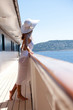 © plprod - femme en maillot et paréo blanc sur le pont d'un bateau en mer