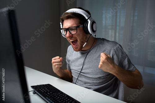 Fotografía man in headset playing computer video game at home