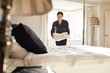 © Monkey Business - Chambermaid placing linen on hotel room bed, low angle view