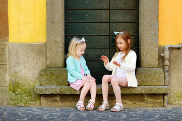 Two adorable little sisters having fun together on warm and sunny summer day