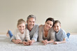 © goodluz - Portrait of cheerful family laying on carpet