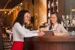 © DragonImages - Bar manager showing waitress new menu on digital tablet